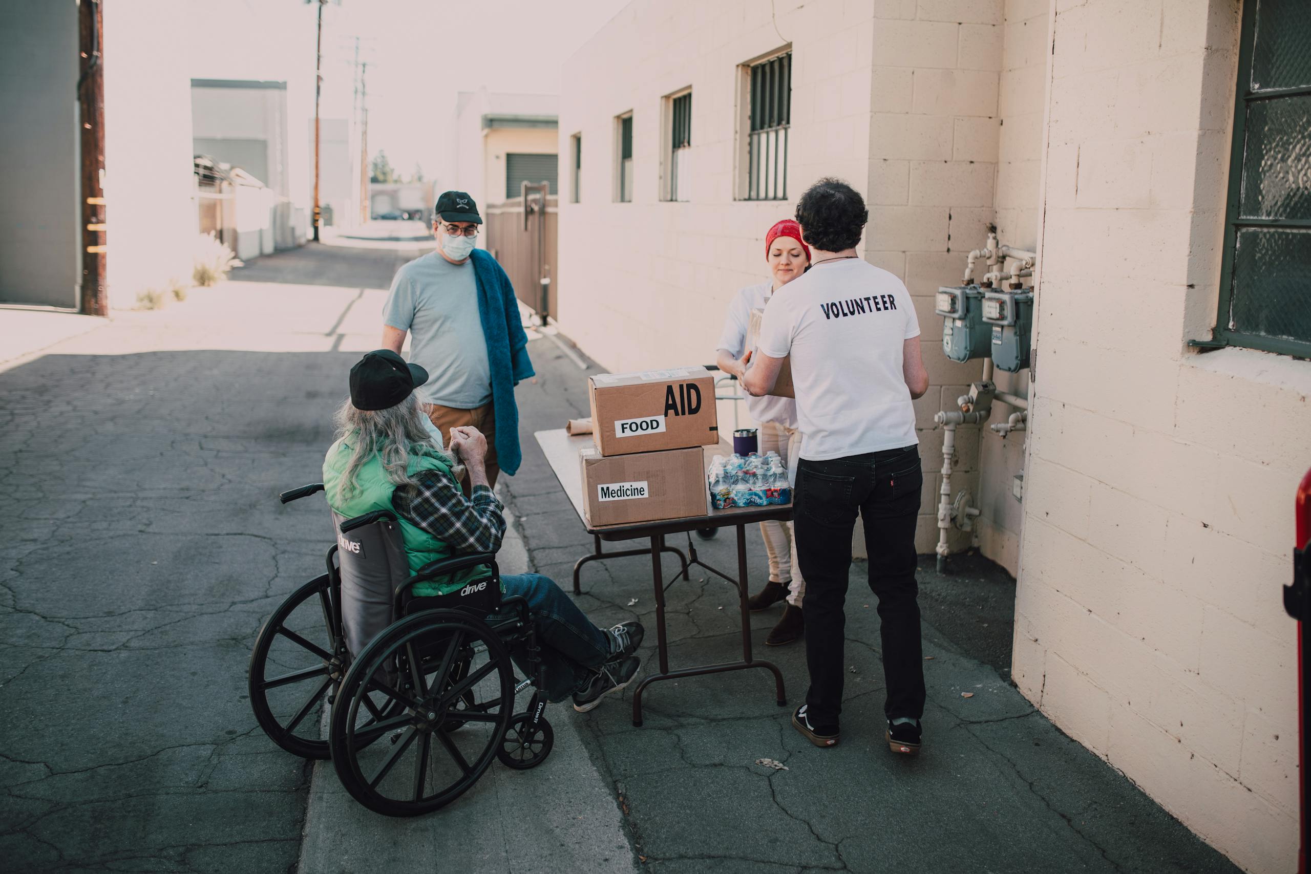 Volunteers distribute food and medicine to those in need, demonstrating compassion and community support.