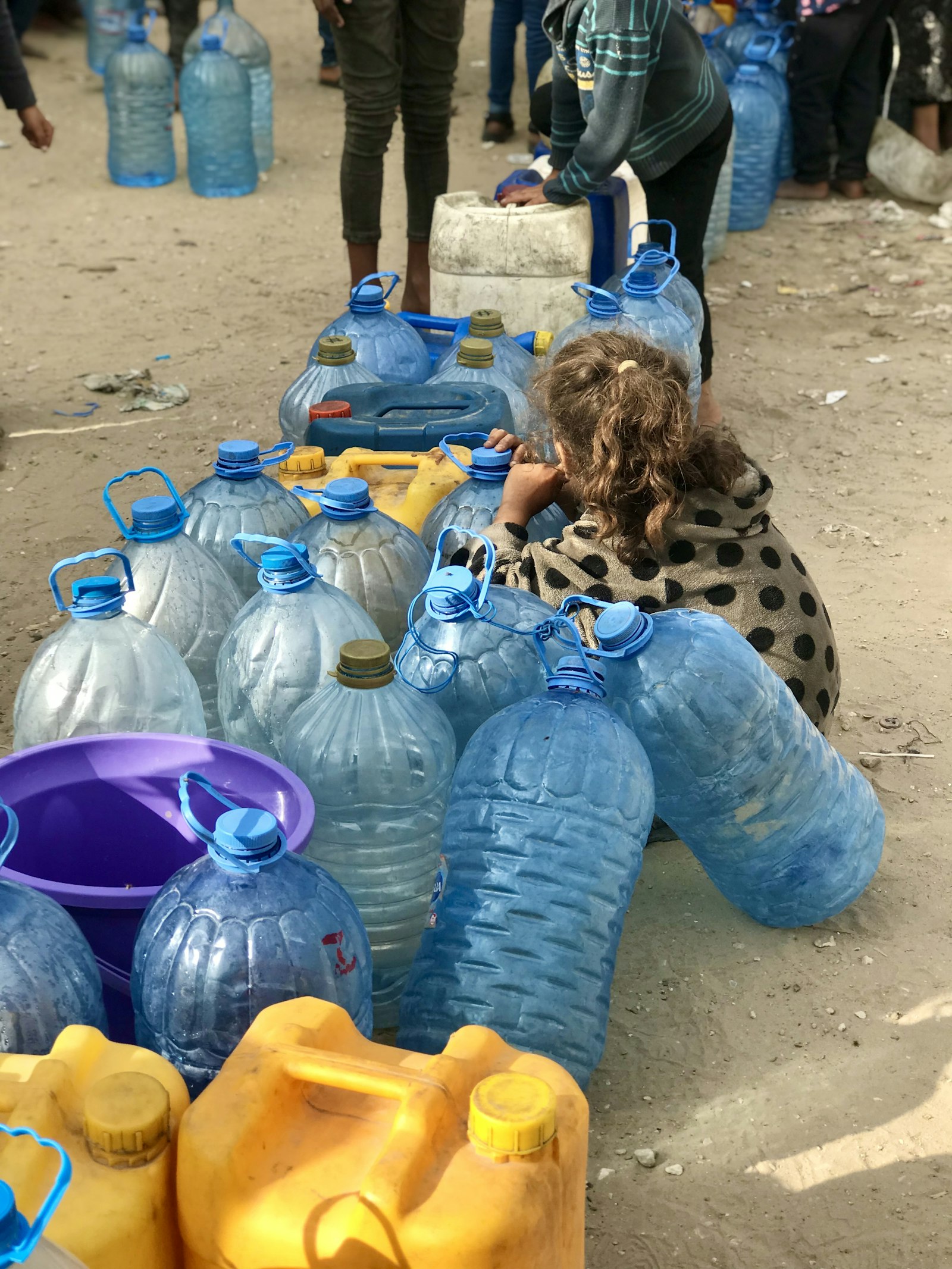 People gathered around a table of bottled water in Gaza City