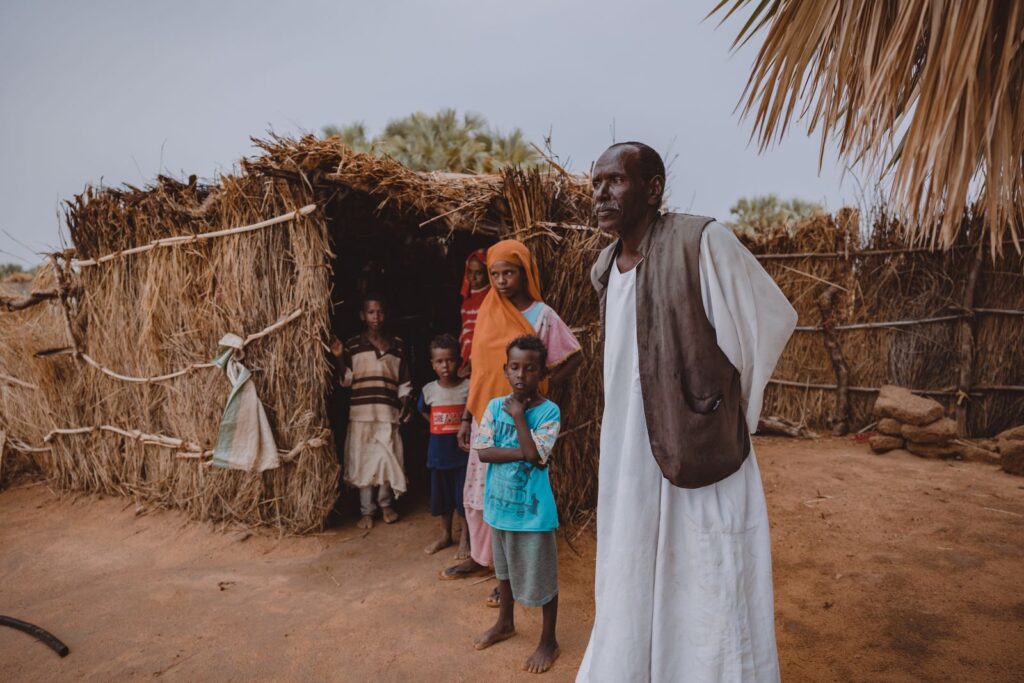 A family outside their straw house in a village in Sudan